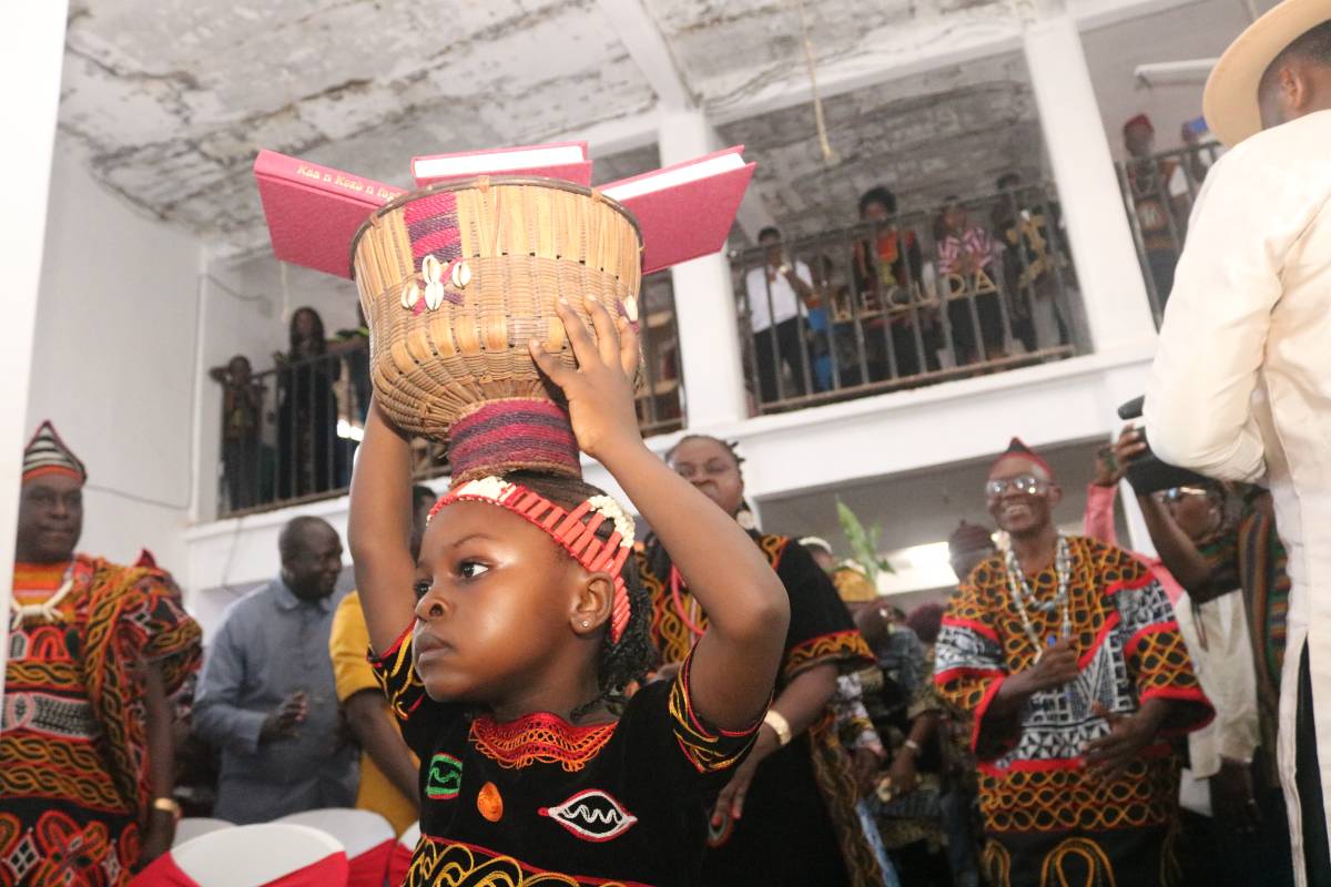 Little girl carrying the New Testament book in a basket at the Weh New Testament dedication in Yaoundé, Cameroon.